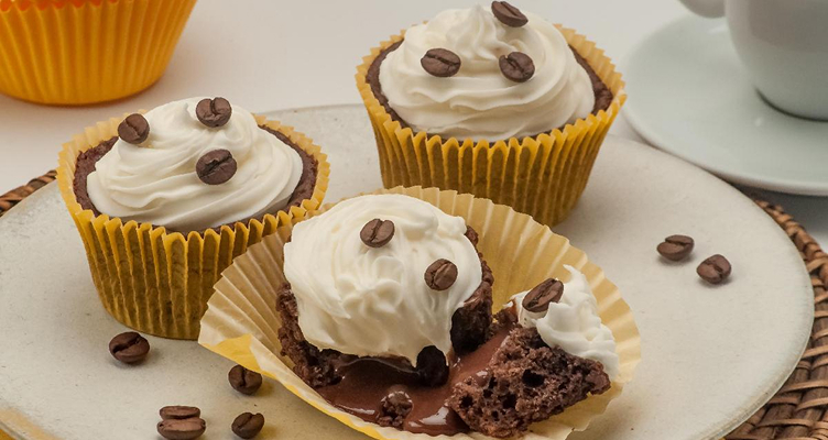 Imagem com um cupcake com graos de chantilly